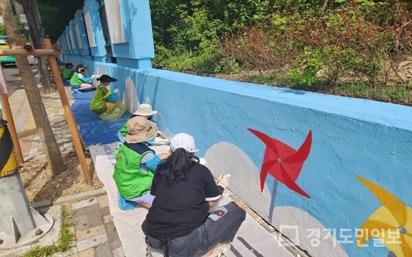 의정부지방법원 및 검찰청 청사 앞 담장에 벽화 그리기 작업을 하고 있는 봉사자들. 