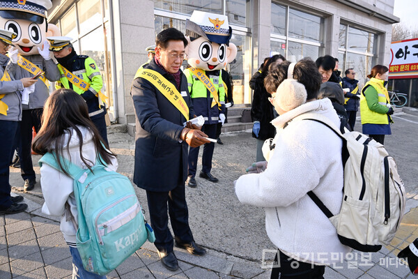 전진선 양평군수가 양평동초등학교 앞에서 실시된 교통안전 캠페인에 참여해 등굣길 학생들에게 핫팩과 학용품을 나눠주고 있다.