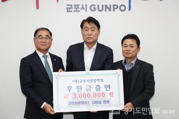 군포상공회의소 김용일 회장이 군포사랑장학회 명예이사장인 하은호(가운데) 군포시장에게 장학금 300만원을 후원하고 있다. 