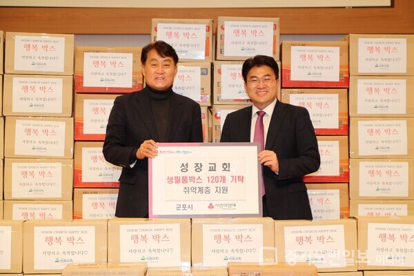 군포시 고산로에 위치한 성장교회가 하은호(왼쪽) 군포시장에게 생필품들이 담긴 박스 120개를 기탁하고 있다.  