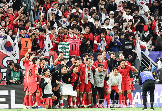 대한민국 축구대표팀 선수들이 대한민국 응원단과 단체사진을 찍고 있다.