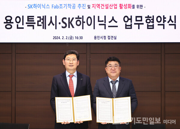 이상일(왼쪽) 용인특례시장이 김동섭 SK하이닉스 사장과 업무협약을 체결하고 협약서를 펼쳐 보이고 있다. 