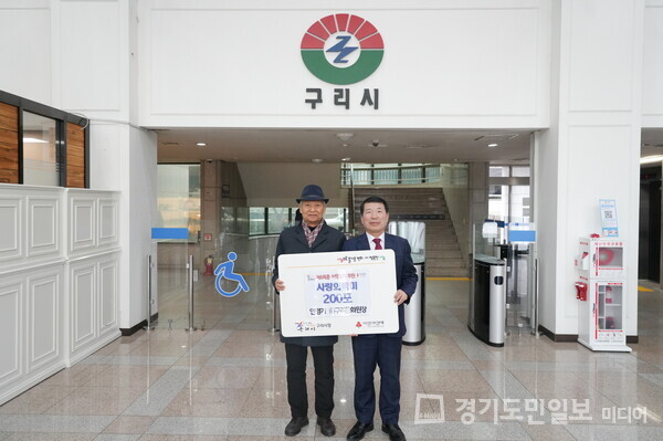 안영기(왼쪽) 전 구리문화원장이 백경현 구리시장에게 취약계층을 위한 백미 200포를 후원하고 있다.