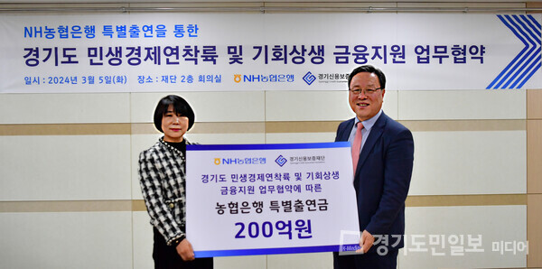 김민자(왼쪽) NH농협은행 경기영업본부장이 특별출연금 200억원을 경기신보 시석중 이사장에게 전달하고 있다. 