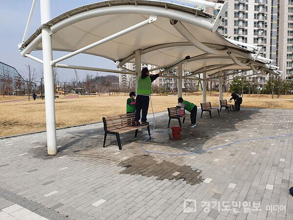 성남시 공원 관리 인력이 모란근린공원 내 벤치 청소를 하고 있다.